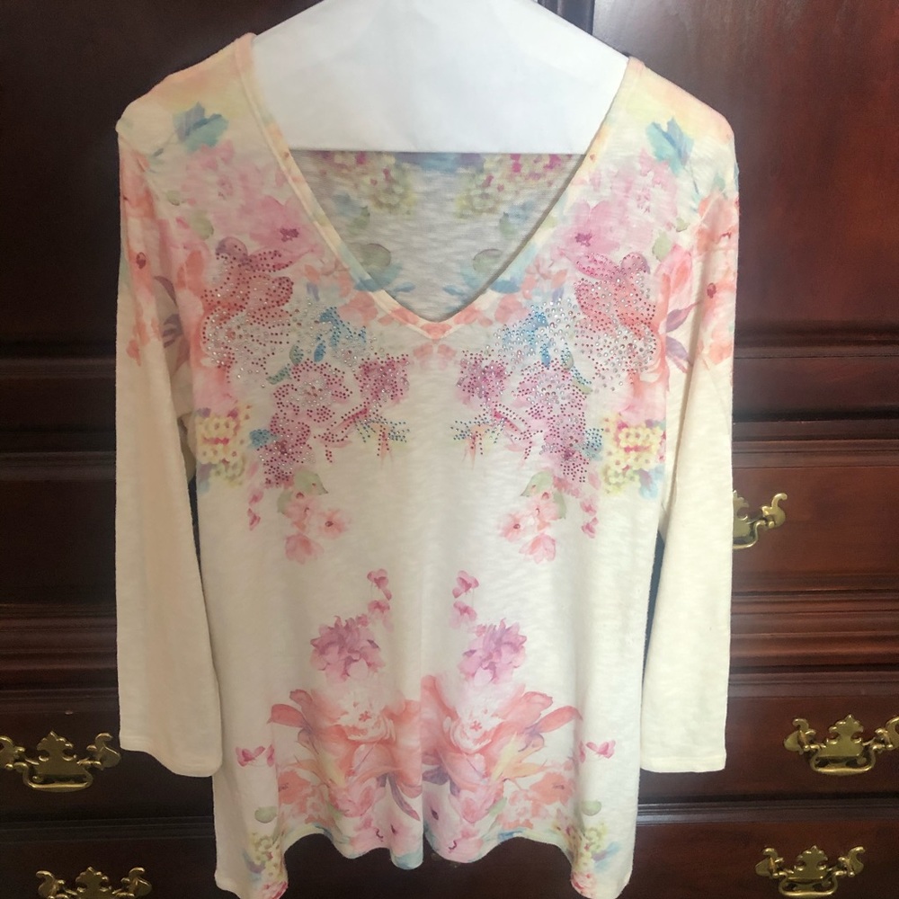 Cream colored tunic top with flowers.